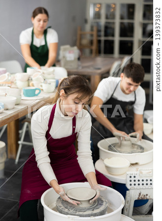 Young woman sculpting product on potter's wheel Young woman sculpting product on potter's wheel 139373832