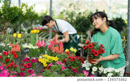 flower shop client chooses flowering petunia in pot instead of bouquet for gift to colleague flower shop client chooses flowering petunia in pot instead of bouquet for gift to colleague 139373862
