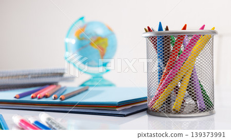 Pencils, globe, workbooks on student table Pencils, globe, workbooks on student table 139373991