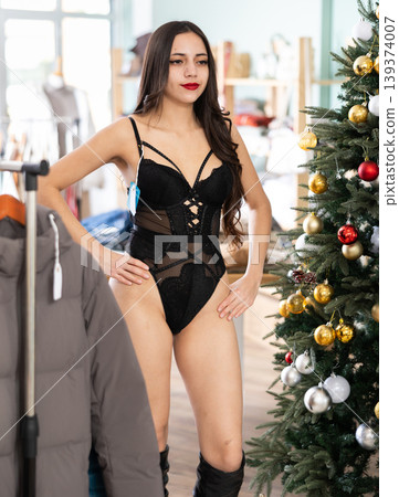 Young woman tries on bodysuit in clothing store Young woman tries on bodysuit in clothing store 139374007