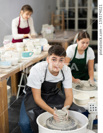 Young man working with pottery wheel Young man working with pottery wheel 139374021