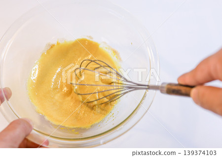The process of mixing choux pastry dough with a whisk - the steps involved in making sweets. The process of mixing choux pastry dough with a whisk - the steps involved in making sweets. 139374103