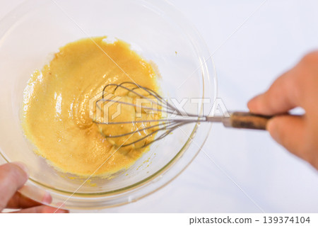 The process of mixing choux pastry dough with a whisk - the steps involved in making sweets. The process of mixing choux pastry dough with a whisk - the steps involved in making sweets. 139374104