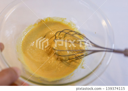 The process of mixing choux pastry dough with a whisk - the steps involved in making sweets. The process of mixing choux pastry dough with a whisk - the steps involved in making sweets. 139374115