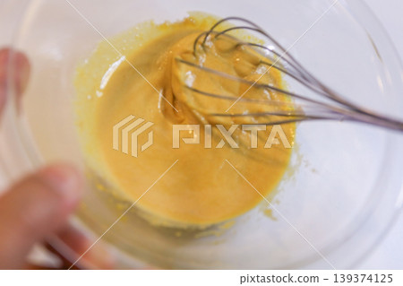 The process of mixing choux pastry dough with a whisk - the steps involved in making sweets. The process of mixing choux pastry dough with a whisk - the steps involved in making sweets. 139374125