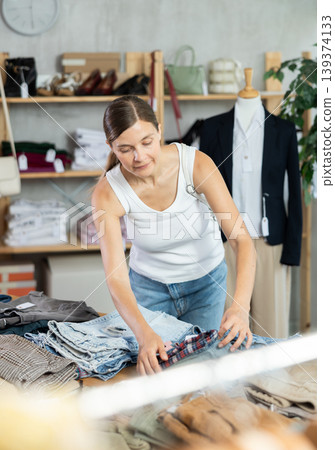 Adult woman choosing jeans in clothing store Adult woman choosing jeans in clothing store 139374133