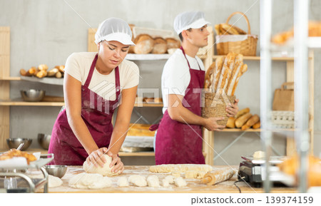 Young woman works in bakery as baker, kneads and prepare dough, works with flour. Young woman works in bakery as baker, kneads and prepare dough, works with flour. 139374159