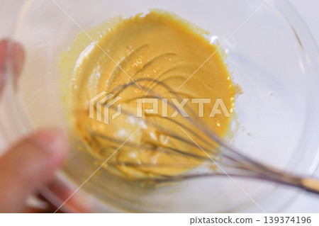 The process of mixing choux pastry dough with a whisk - the steps involved in making sweets. The process of mixing choux pastry dough with a whisk - the steps involved in making sweets. 139374196