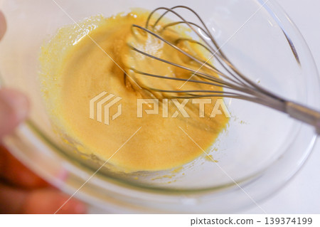 The process of mixing choux pastry dough with a whisk - the steps involved in making sweets. The process of mixing choux pastry dough with a whisk - the steps involved in making sweets. 139374199