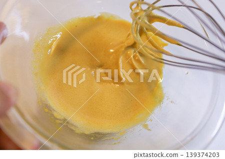 The process of mixing choux pastry dough with a whisk - the steps involved in making sweets. 139374203