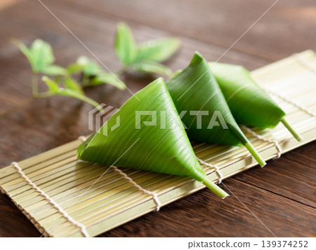 Wheat gluten dumplings wrapped in bamboo leaves - a seasonal Japanese confection. Wheat gluten dumplings wrapped in bamboo leaves - a seasonal Japanese confection. 139374252