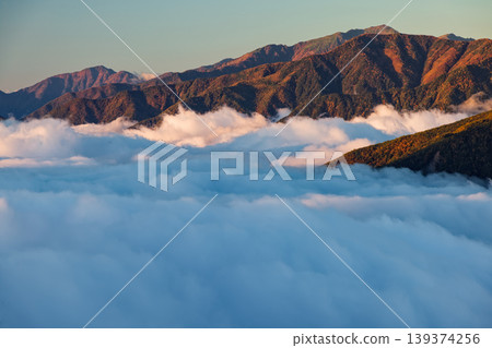 A sea of clouds and the sunrise over Mt. Arakawa as seen from the Houou Sanzan mountain range in the Southern Alps and Tsue-tate Pass. A sea of clouds and the sunrise over Mt. Arakawa as seen from the Houou Sanzan mountain range in the Southern Alps and Tsue-tate Pass. 139374256