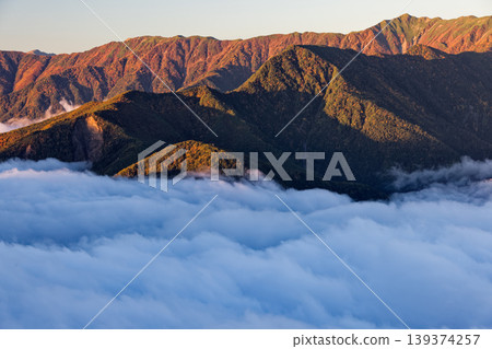 從南阿爾卑斯山的侯王三山和辻立峠望去，可以看到雲海籠罩著沐浴在晨光中的山脈。 139374257