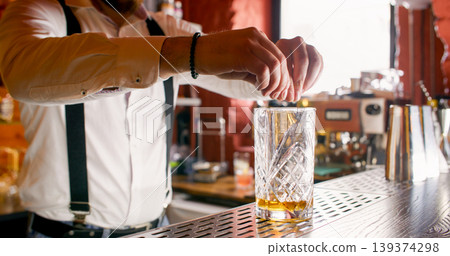 Fresh cocktail. Alcohol beverage. Unrecognizable professional male barman hands serving decorating drink on bar counter. Fresh cocktail. Alcohol beverage. Unrecognizable professional male barman hands serving decorating drink on bar counter. 139374298