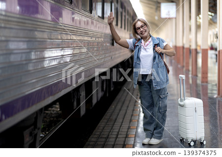 Asian adult woman traveler waving smiling train station platform suitcase ready journey transportation travel adventure destination Asian adult woman traveler waving smiling train station platform suitcase ready journey transportation travel adventure destination 139374375