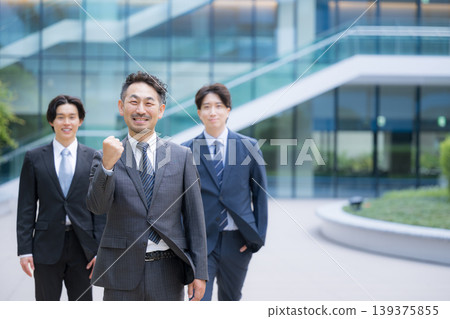 Three or more people, including consultants, are seen smiling and looking directly at the camera in a business setting, striking a triumphant pose in a video about job hunting and organizational building. 139375855