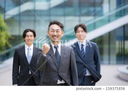 在一段關於求職和組織建設的影片中，可以看到三名或更多人（包括顧問）面帶微笑，直視鏡頭，在商業環境中擺出勝利的姿勢。 139375856