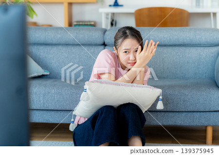 A young lady watching TV in the living room A young lady watching TV in the living room 139375945