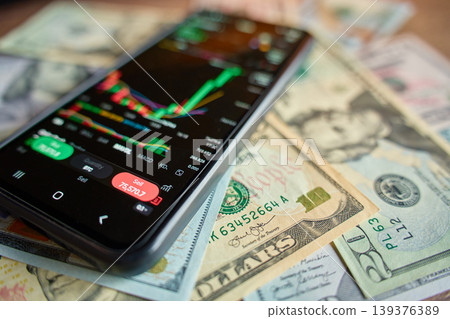 Smartphone with mobile trading app on US dollar banknotes Smartphone with mobile trading app on US dollar banknotes 139376389