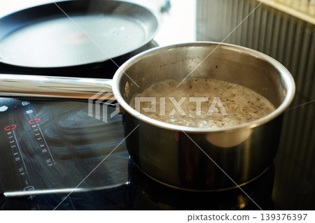 Saucepan with boiling oatmeal porridge on induction cooktop 139376397
