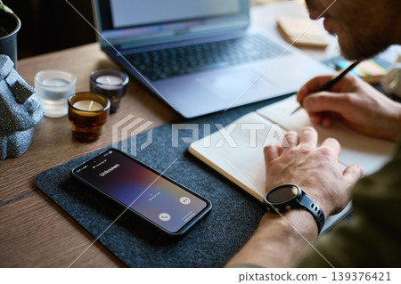 Unknown phone call during work at desk with notebook Unknown phone call during work at desk with notebook 139376421