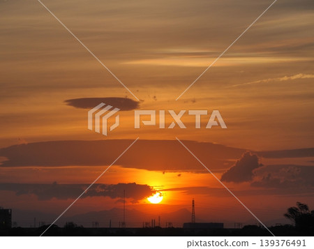 夕陽將天空染成橘色,太陽緩緩沉入城市之下。 夕陽將天空染成橘色,太陽緩緩沉入城市之下。 139376491