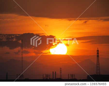 夕陽將天空染成橘色,太陽緩緩沉入城市之下。 夕陽將天空染成橘色,太陽緩緩沉入城市之下。 139376493