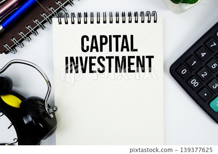 Capital Investment text written on notepad with calculator and alarm clock 139377625