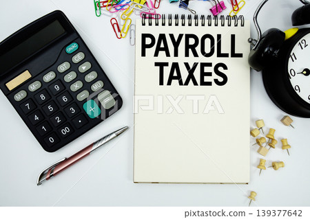 Payroll Taxes text written on notepad with calculator and alarm clock Payroll Taxes text written on notepad with calculator and alarm clock 139377642