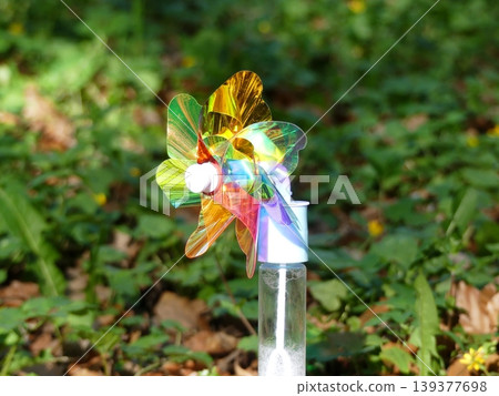 Iridescent pinwheel on bubble bottle in forest Iridescent pinwheel on bubble bottle in forest 139377698