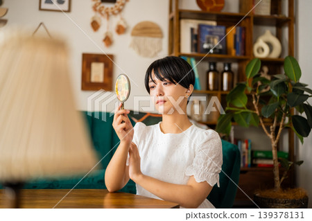 A woman looks at something with a magnifying glass. 139378131