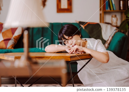 一個女人睡在桌子上。 139378135