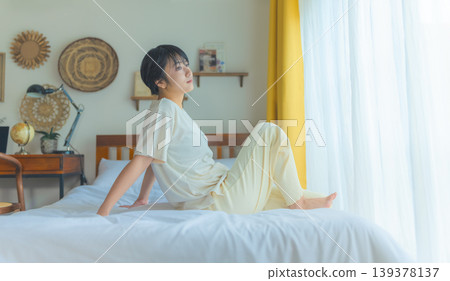 A young woman relaxing in bed A young woman relaxing in bed 139378137