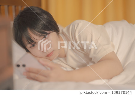 A woman watching a smartphone in bed A woman watching a smartphone in bed 139378144