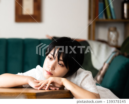 The woman leans against the table. The woman leans against the table. 139378145
