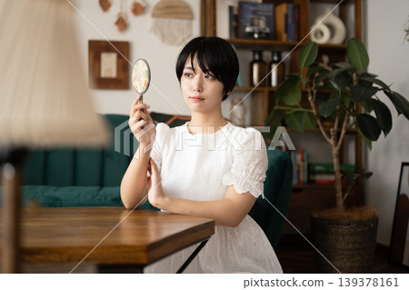 A woman peers through a magnifying glass. 139378161