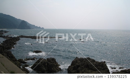 A view of waves crashing against the rocky shore and a cape. A view of waves crashing against the rocky shore and a cape. 139378225