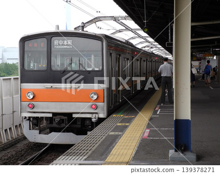 一名列車員在京葉線新木場站的月台上查看時間。 一名列車員在京葉線新木場站的月台上查看時間。 139378271
