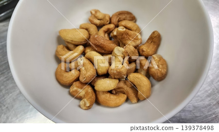 Roasted Salted Cashew Nuts in a White Ceramic Bowl - Healthy Snack Food Roasted Salted Cashew Nuts in a White Ceramic Bowl - Healthy Snack Food 139378498