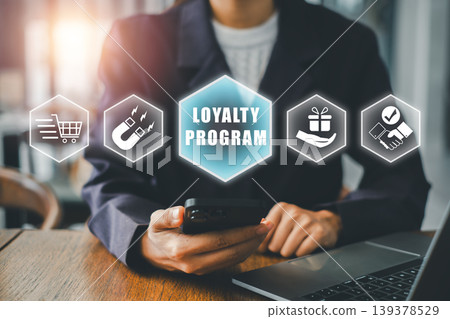 Professional woman using smartphone for loyalty program in office, surrounded by digital marketing icons. 139378529