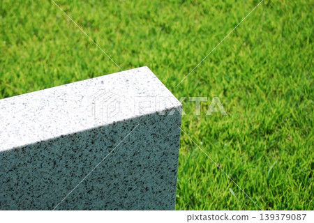 Corner of a stone structure placed on the lawn Corner of a stone structure placed on the lawn 139379087