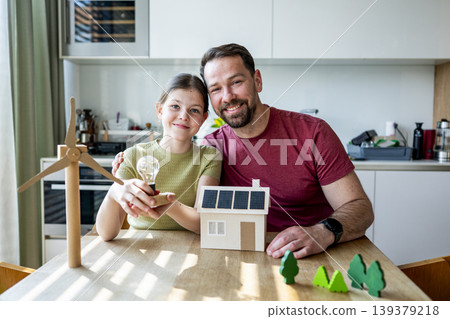 Father teaching daughter about renewable energy and ecology at home. Father teaching daughter about renewable energy and ecology at home. 139379218