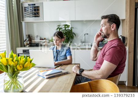 Family balancing work and education at home with father and child together. 139379233