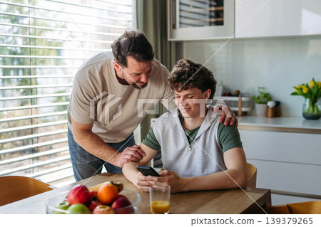 Father supporting teenage son at home during everyday moment. Father supporting teenage son at home during everyday moment. 139379265
