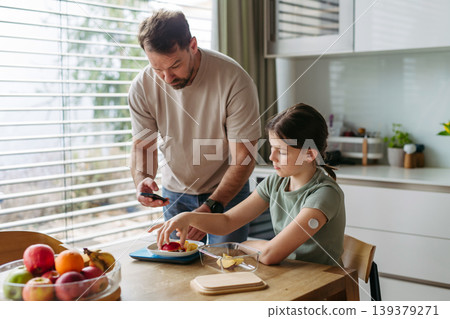 Parent helping diabetic daughter understand nutrition and sugar content. Parent helping diabetic daughter understand nutrition and sugar content. 139379271