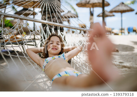 Smiling girl relaxing in hammock during tropical family vacation. 139379318