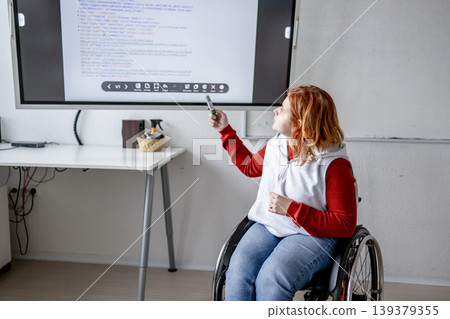 Female student in wheelchair presenting her project in front of classroom. Female student in wheelchair presenting her project in front of classroom. 139379355