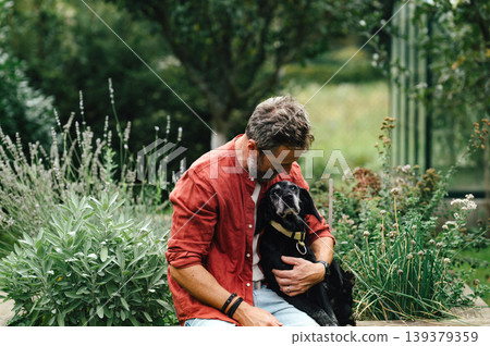 Man hugging senior dog with affection. Man hugging senior dog with affection. 139379359