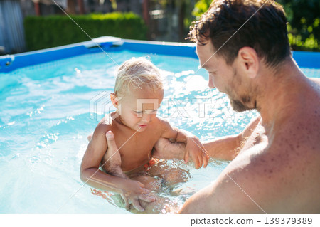Father trying to teach little boy to swim. Father trying to teach little boy to swim. 139379389