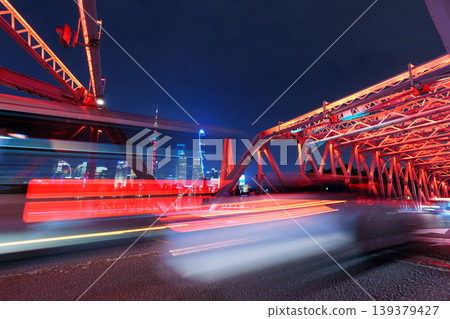Long-exposure nighttime photos of Shanghai Waibai Bridge: Low-angle shots of the steel structure and light trails. 139379427